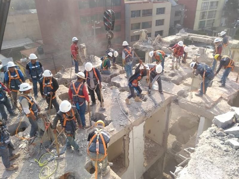 Cuadrilla numerosa demoliendo la estructura de un edificio