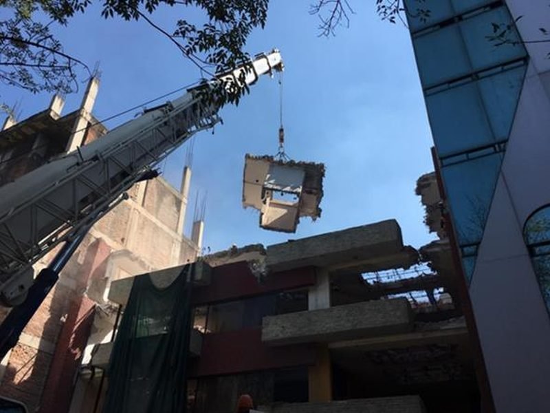 Grúa izando una sección de losa durante una demolición