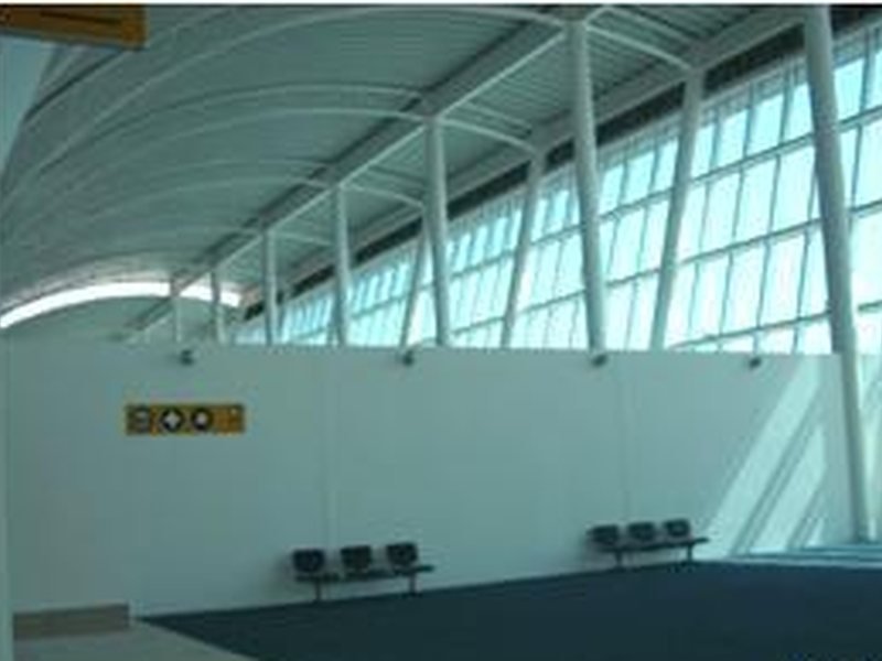 Sala de última espera de la terminal, con cubierta curva y muro cortina de cristal